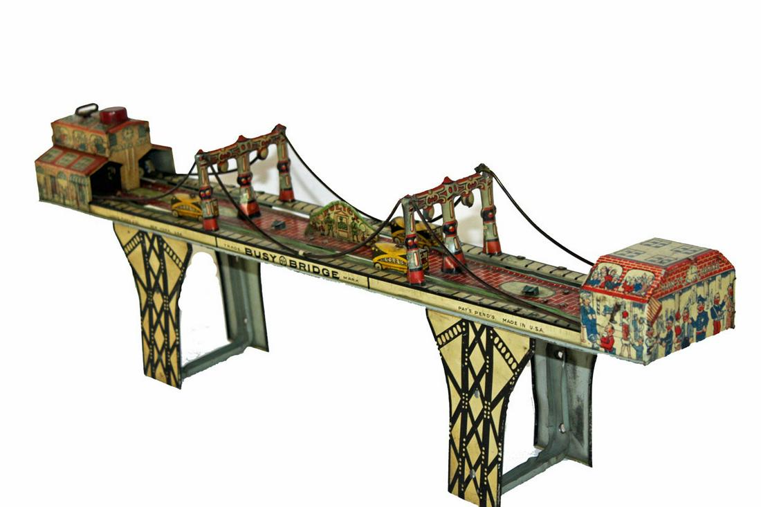 Marx Busy Bridge: Marx keywind Busy Bridge tin toy. Marked on side: Louis Marx & Co., New York, U.S.A. Marx seal. Patents pending, Made in U.S.A. Wind the key mechanism and the cars travel back and forth across the Bus