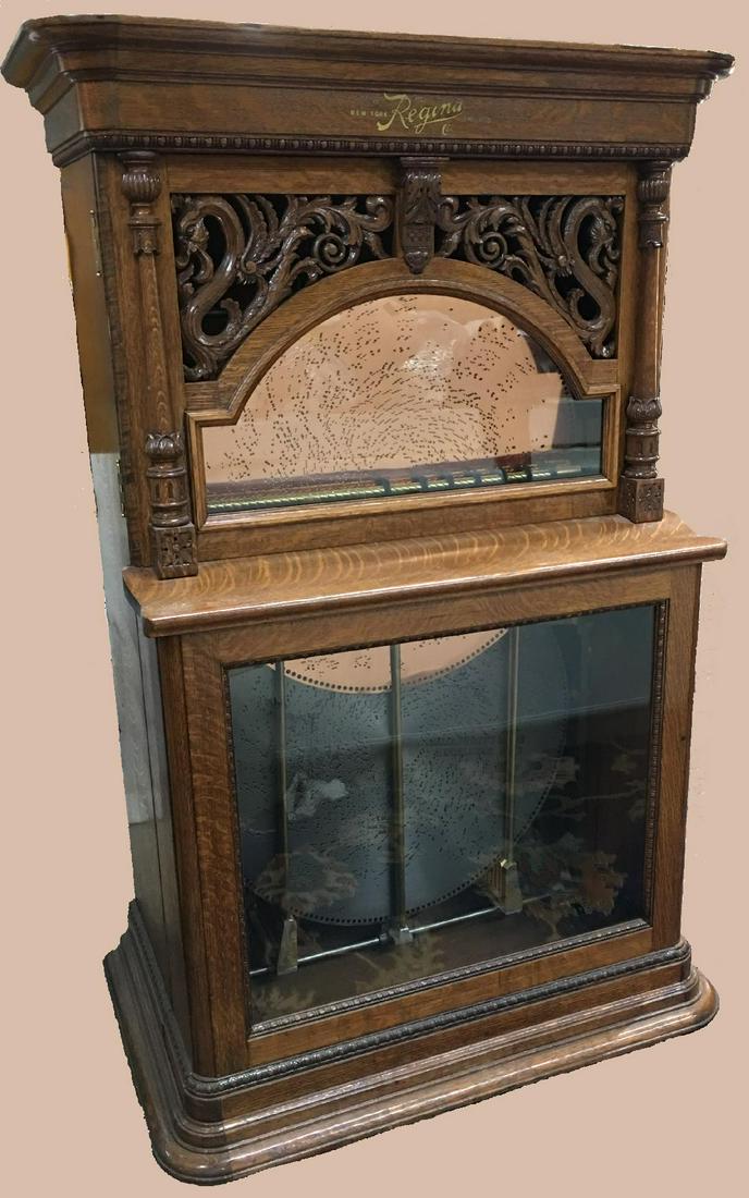 Beautifully carved Dragon Front design known as the: Beautifully carved Dragon Front design known as the Style 8A Regina. Splendid cabinet carved in quarter sawn white oak with a beautiful original patina. The cabinet holds 12 discs that automatically r