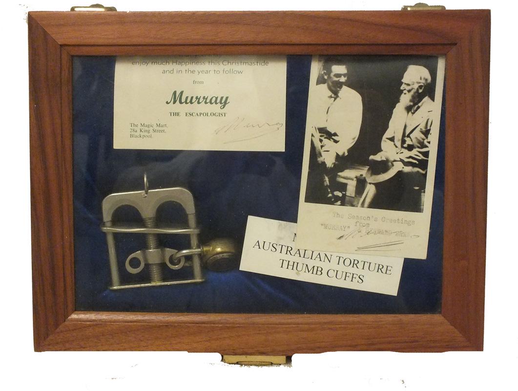 Australian Torture Thumb Cuffs in display case with two: Australian Torture Thumb Cuffs in display case with two Christmas cards signed "Murray" and card denoting that the cuffs belonged to Murray. Velvet lined case measures approx. 9" x 12" x 2.25" deep.