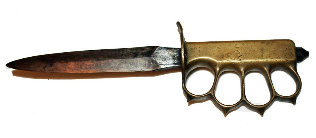 Large Trench Art knife with open work handle resembling: Large Trench Art knife with open work handle resembling brass knuckles. Blade that is sharp on both sides is approx. 6.75" long. Total length with handle approx. 11."