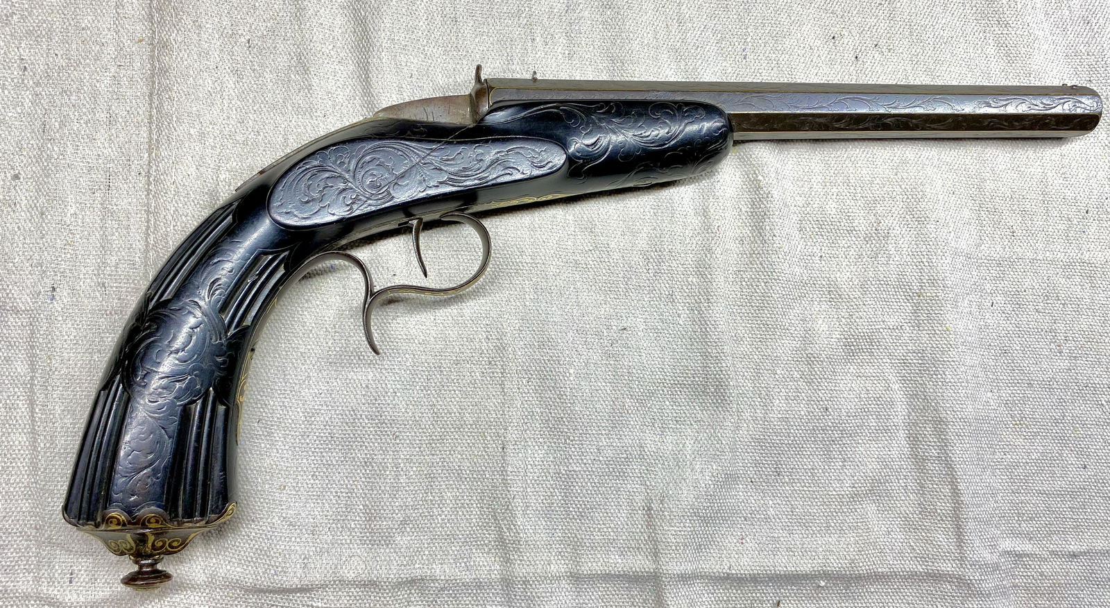 French target pistol, single shot, breech load, center: French target pistol, single shot, breech load, center fire, .22 caliber. All furniture sporting gold inlay and intensive engraving. Stock is highly carved East Indian rosewood. Ca. 1870.