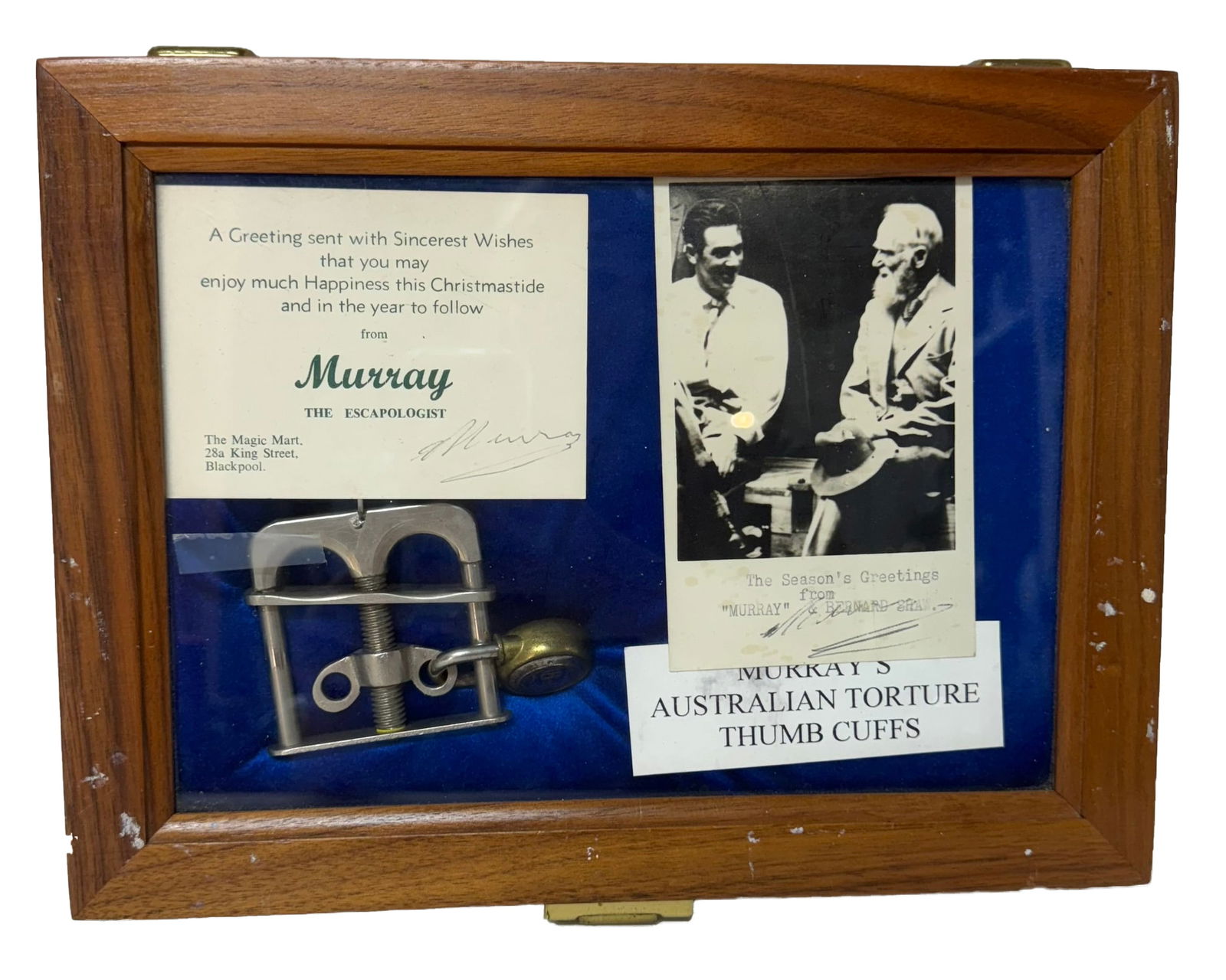 MURRAY THE MAGICIAN AUSTRALIAN TORTURE THUMB CUFFS: Australian torture thumb cuffs in display case with two Christmas cards signed "Murray" and card denoting that the cuffs belonged to Murray. Velvet lined case measures approx. 9 x 12 x 2.25 inches in