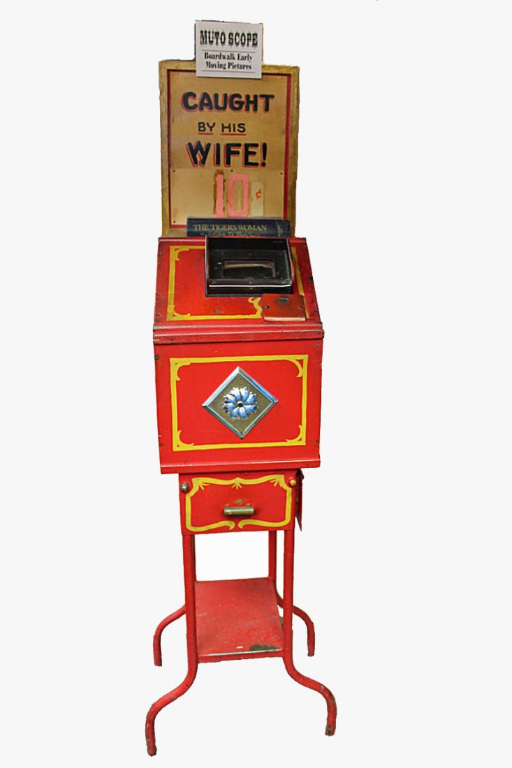 Mutoscope: Mutoscope on metal legs with body being constructed of woor. Painted and electrified. Movie on reel is entitled "Caught by his Wife." Works on a dime coin.