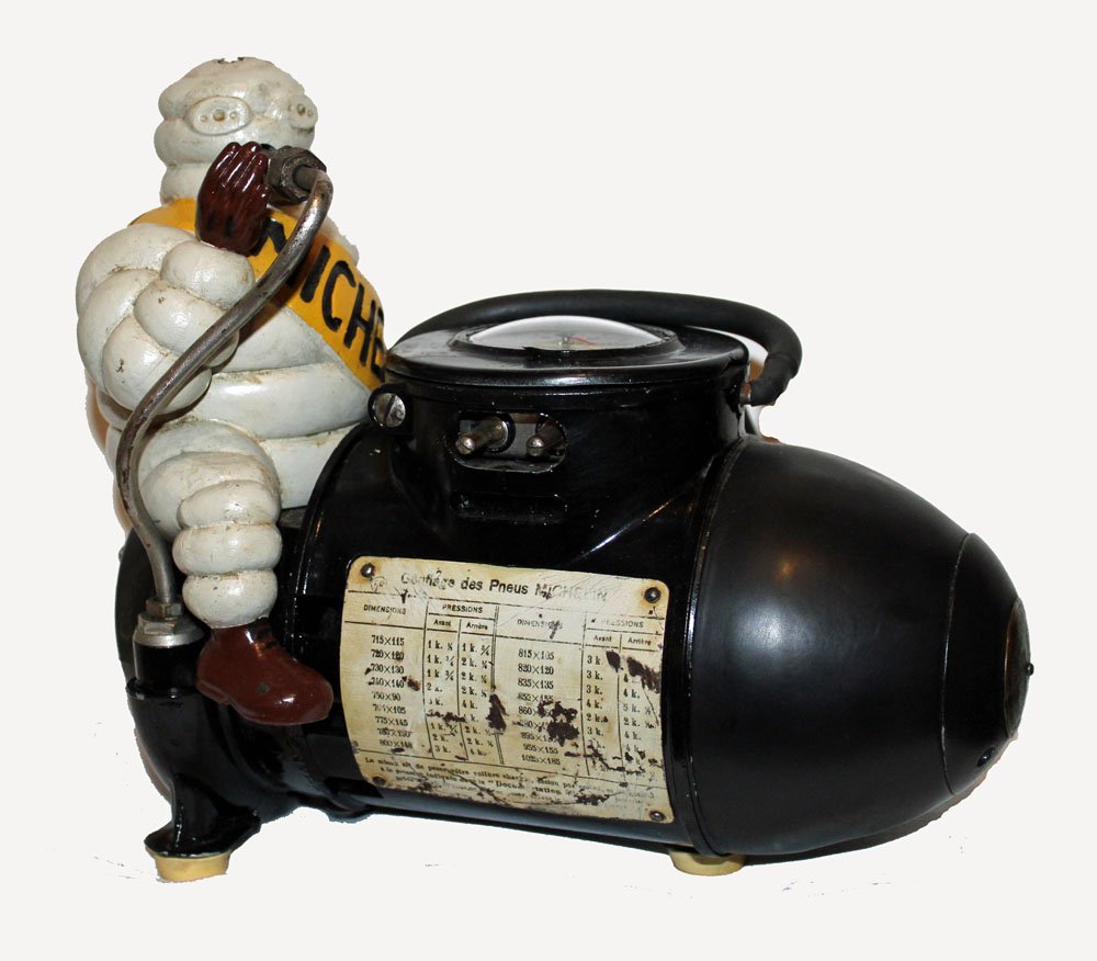 Michellin Man Air Pump: Small Michelin Man air pump sitting astride air pump.