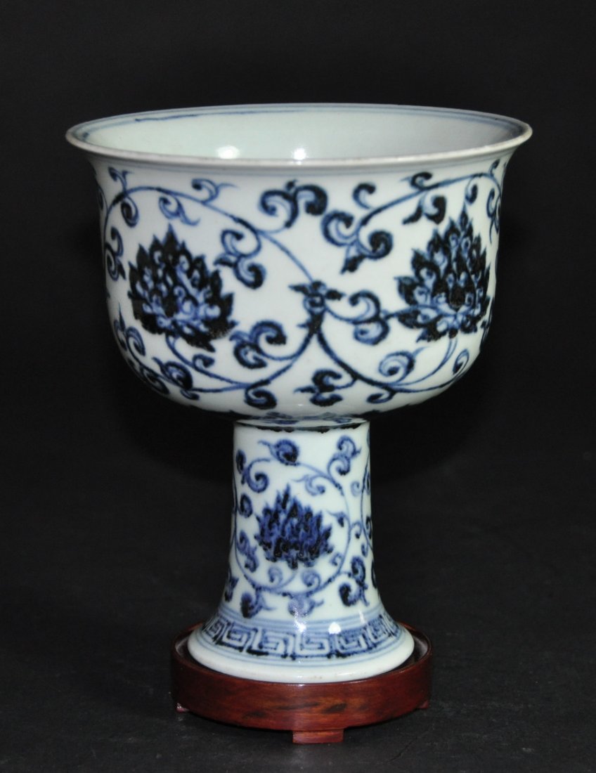 A Ming Dynasty blue and white high leg cup: This piece is decorated with floral and vine patterns. Height 18.5cm. Rim diameter 15cm