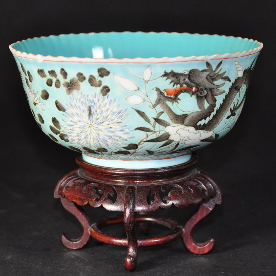 A Turquoise ground porcelain bowl.Qing Period: Qianlong Mark, Qing Period.The bowl with fluted rim, opaque turquoise enamel covering the interior, surrounding the dragons and flowering branches in various enamels on the exterior and on the recesse