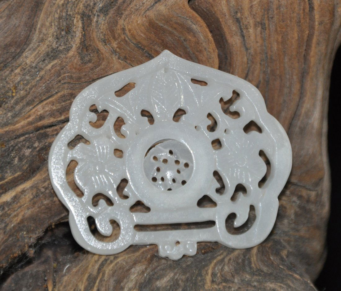 A white jade plaque: This piece is carved in a pecular shape and the inner carving is mobile. Diameter 7.5 cm