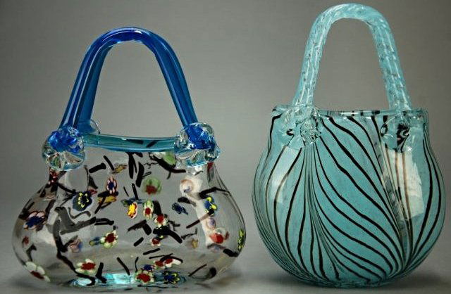 A lot of 2 blown glass purses: These pieces are very peculiar, the glass is stylised as a set of purses. On each purse is an array of multi colored patterns and designs. Height 8 in & 8.2 in, Length 7.5 in & 5.5 in