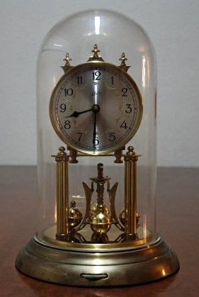 A German antique clock: This piece is very beautiful. It comes with a glass covering. Height 12 in
