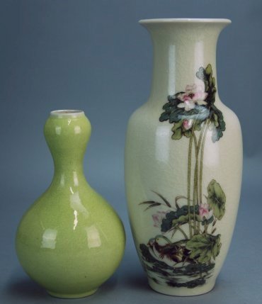 Two fencai vases: The piece on the right is decorated with flowers and lily pads and features crack like patterns. The other piece is a lemon-yellow bulb vase. Height of bulb vase 7 in, Height of flower vase 10.2 in