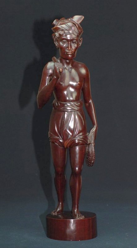 A Bali Wood carving of a man: This piece is signed by A.A. Fatimah, Bali. A.A. Fatimah was renowned for his ebony sculptures, but also made use of other local hardwoods, such as sandalwood. His peak of production was in the 1940's