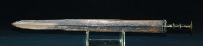 A rare copper and bronze bi-metallic jian Eastern Zhou: A rare copper and bronze bi-metallic jian Mid Eastern Zhou dynasty, Yue cultureThe scalloped, rhomboid cross-section blade and edge with pronounced median ridge waisted towards the point, well preserv