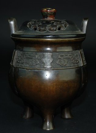 An ancient bronze tripod: The bronze tripod body carved with ancient pattern.Handlesand three columnar feet Decorated with tao-t'ieh design over thunder pattern background. Provenance: A British private collection. Height 15 c