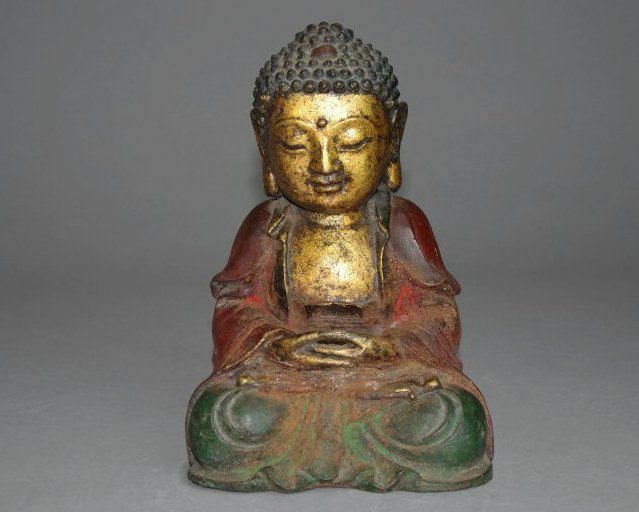 A Ming dynasty cast bronze figure of a Buddha: This piece is a gilt bronze and painted piece. This Buddha is seen in a meditation stance. Height 23 cm , Width 15 cm .