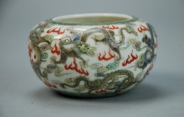 A Qing Dynasty enamel nine dragon brush washer: This piece is very magnificent. There are nine dragons in total, each one is a different color. In the background are clouds and flames. Diameter 7.5cm, Height 5cm.