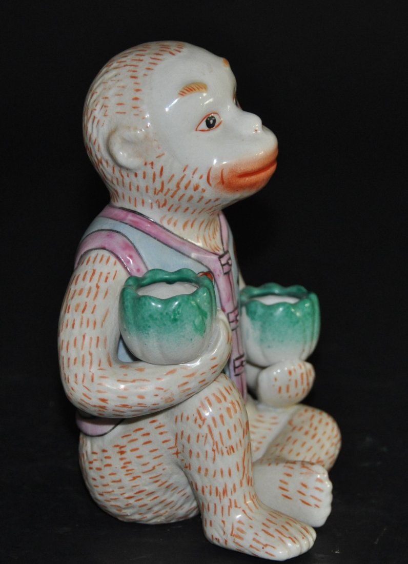 A famille rose monkey figure: This piece features a monkey holding two floral cups and wearing a vest. Height 18 cm