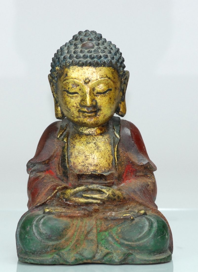 A Ming dynasty cast bronze figure of a Buddha: This piece is a gilt bronze and painted piece. This Buddha is seen in a meditation stance. Height 22.5cm, Width 15cm.
