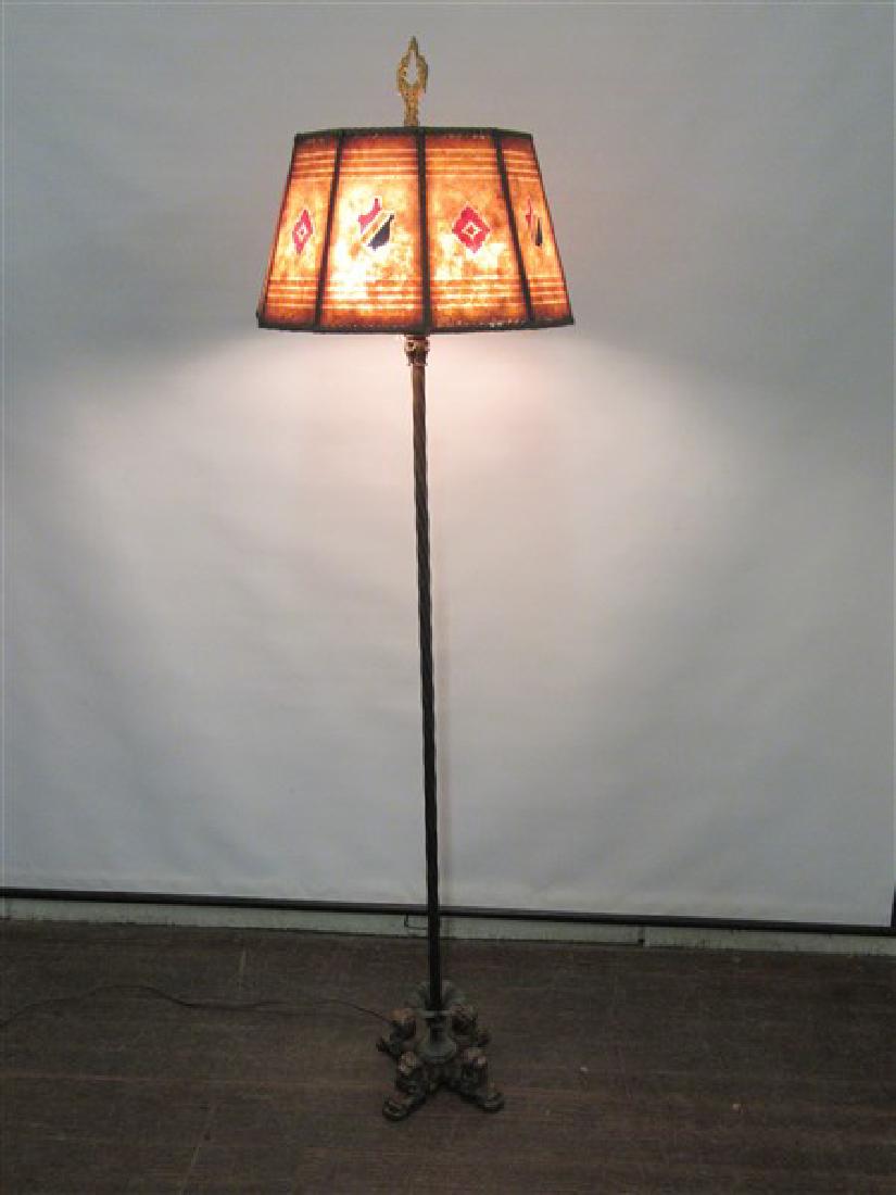 Vintage Iron Floor Lamp with Mica Shade: Early 20th century cast iron floor lamp with figural dogs at base. A period mica shade set at top. Dimensions: 61"h X 16" shade diameter.