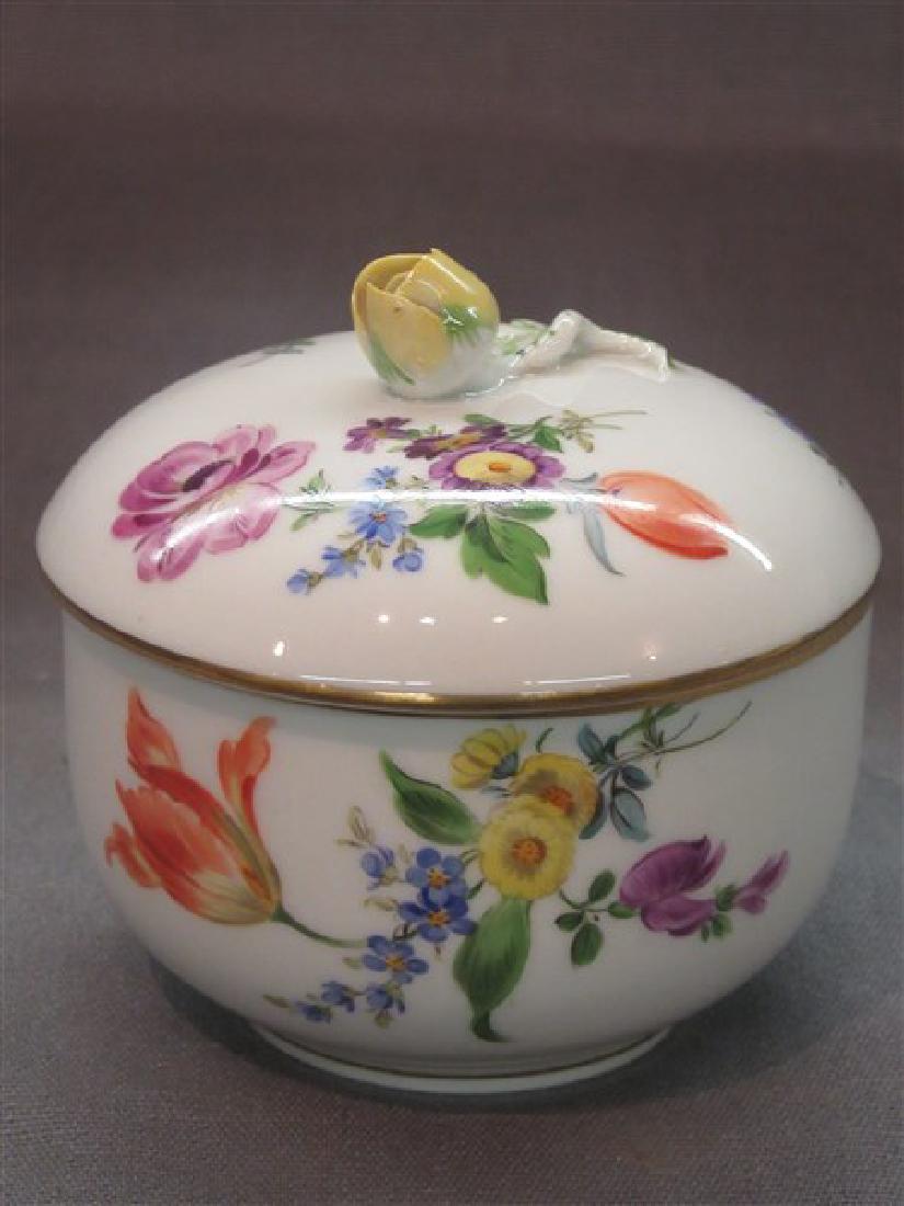 Meissen Porcelain Covered Pot: A small Meissen porcelain covered pot with figural flower finial and hand painted floral sprays. Cross swords and numbering at base. Dimensions: 4 1/4" X 4"