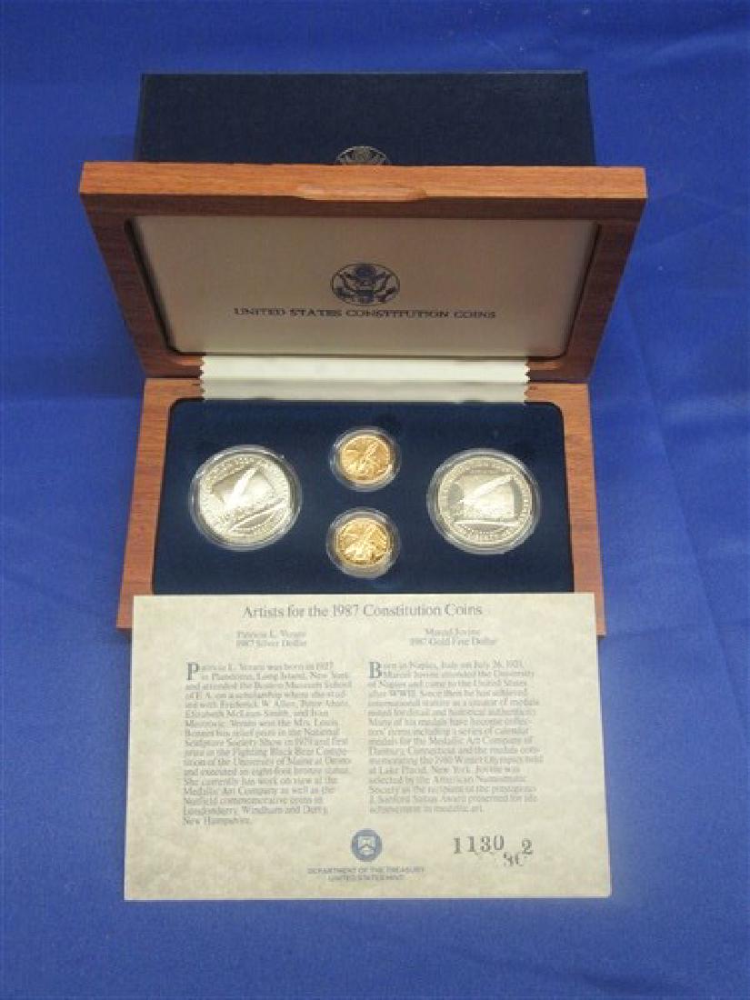 1987 US Gold And Silver Constitution Coin Set: A 1987 Six (6) Piece gold and silver US Constitution coin set. Including Two (2) $5 gold and Four (4) $1 Silver. Housed in a hardwood box.