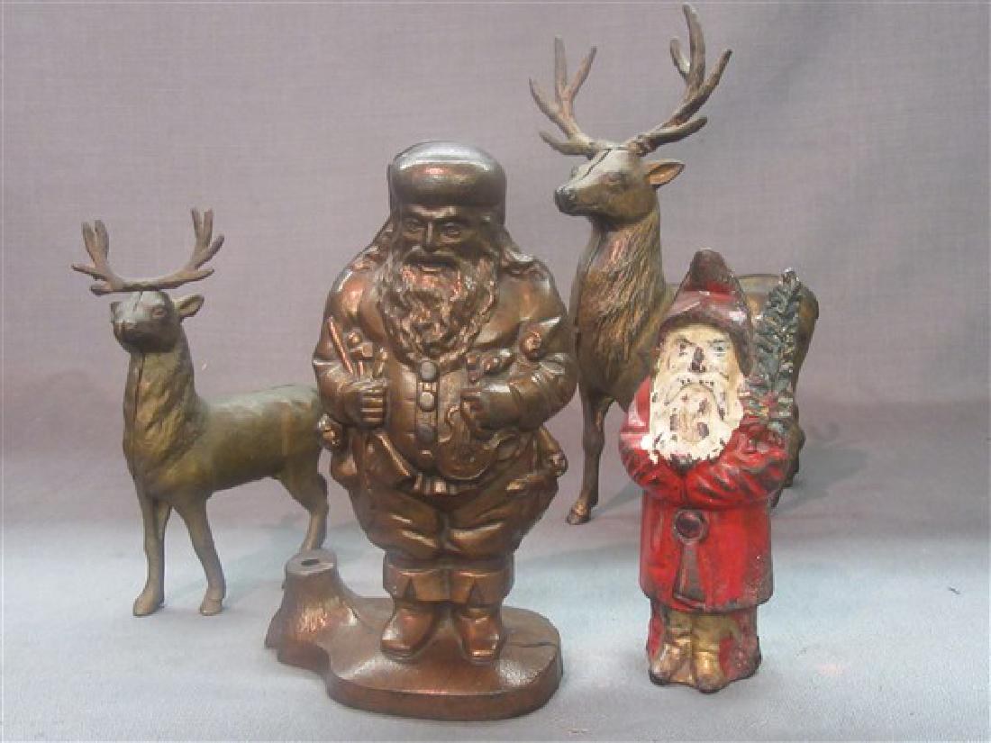 Four Cast Iron Banks Santas and Deers: A grouping of Four (4) still banks. Includes a circa 1910 Hubley 6" Father Christmas with original polychrome paint. Also, newer 7-1/2" Santa Claus and Two (2) Reindeer measuring 9-1/2 and 6-1/4" tall