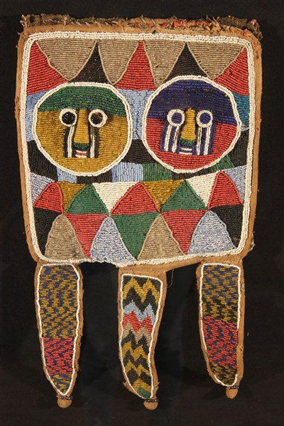 Nigerian Beaded Animal Hide Diviner's Bag Circa 1920: A Nigerian beaded animal hide Diviner's bag, Piece Yoruba tribe, circa 1920, with central mask faces, presumably representing Eshu, and Three (3) hanging feather shaped beaded elements, no visible str