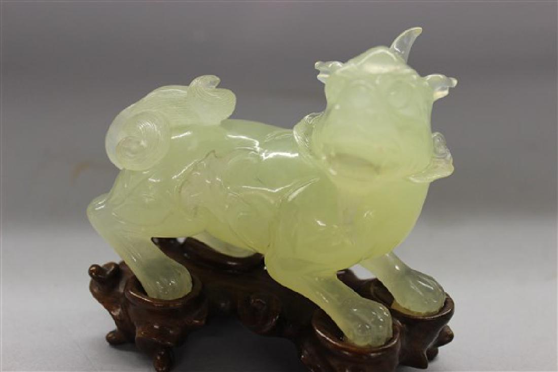 Chinese Carved Jade Foo Dog: An antique Chinese carved jade foo dog on exotic hardwood base. Dimensions: 4 1/2" X 4 1/2" X 2"