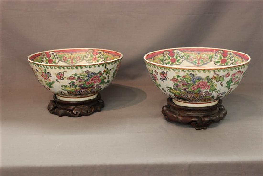 Pair, Chinese Famille Rose Signed Porcelain Bowls: A pair of Chinese Famille Rose polychrome paint enamel porcelain bowls. One bowl signed at base. Set on wooden bases. Dimensions: 4 1/2"h X 10"d Provenance: Newburgh, NY Estate