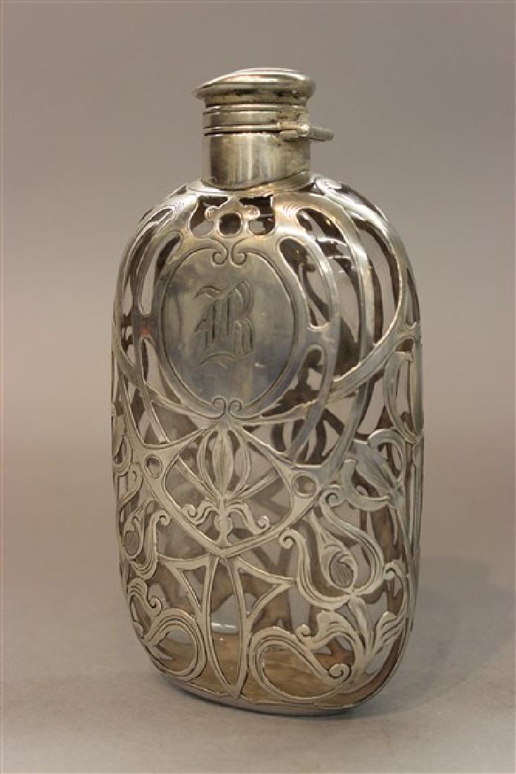 Art Nouveau Flask With Sterling Silver Overlay: An Art Nouveau period flask with sterling silver overlay and top. Dimensions: 6" X 3 1/4"