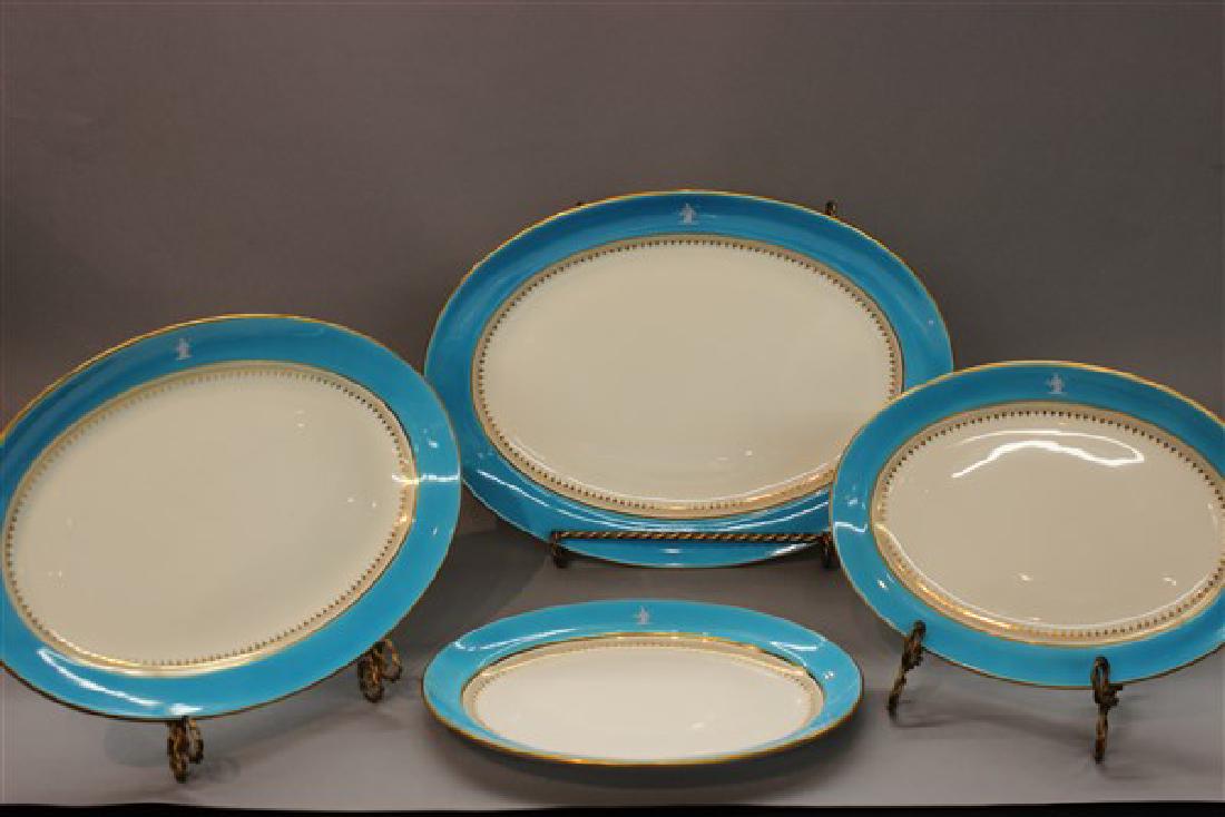 Minton Turquoise Blue Pat Sur Pate Porcelain Platters: Four (4) Minton turquoise blue and white porcelain dinnerware platters. Signed Minton's China T. Goode & Co. London. A most fine silhouette figure of a nobleman with loosely paint decorated ribbon top