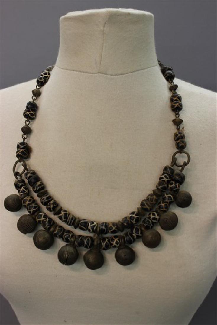 African Trade Bead And Bell Necklace: c.1900 African trade bead necklace with brass bells. Dimensions: 11" Drop Provenance: From the collection of the late Mr. Paul Kramer, Chicago, IL.