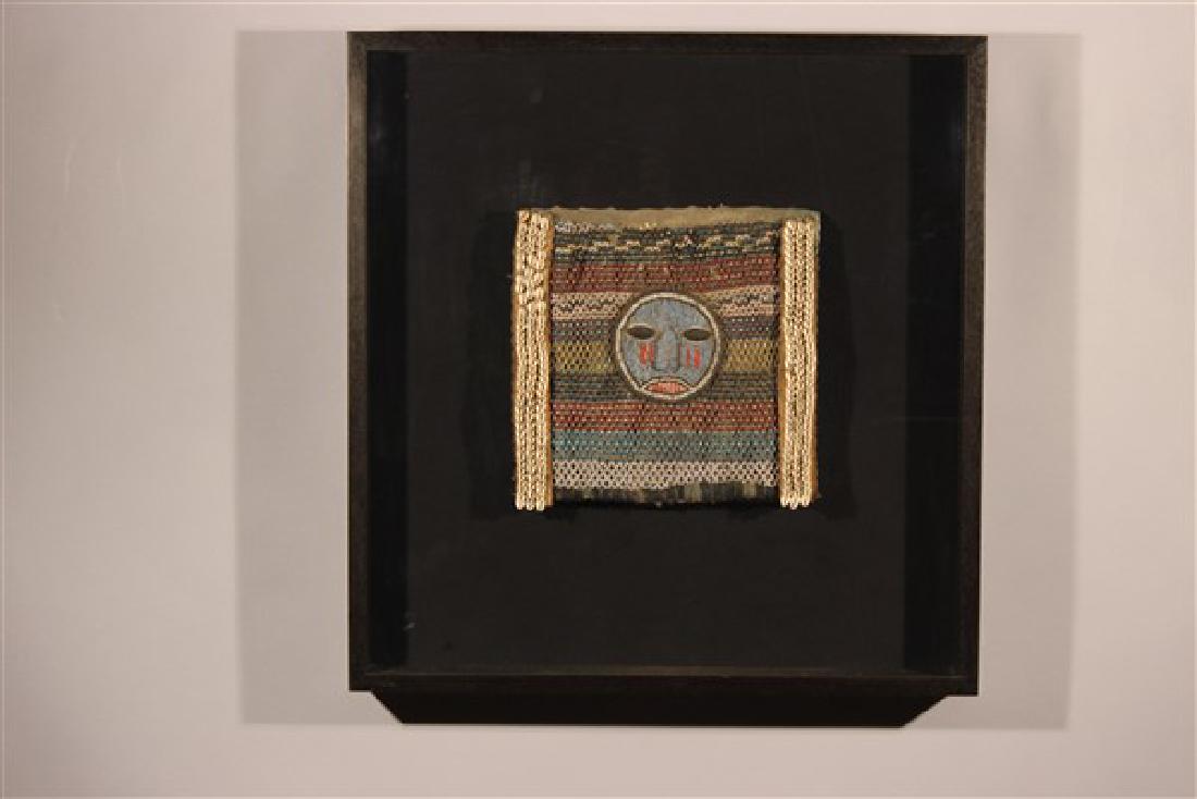 Nigerian Beaded Animal Hide Diviner: A Nigerian beaded animal hide Diviner's bag, Yoruba tribe, circa 1920, with central mask face and horizontal bands of beaded decoration, no visible strap Dimensions: 12" X 12 1/2" Mounted in ebonized 