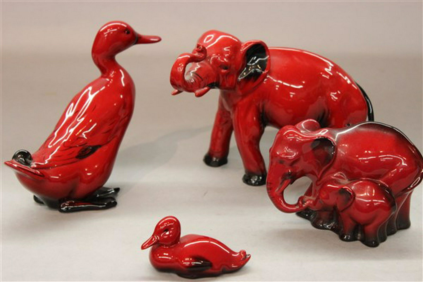 Four (4) Piece Royal Doulton Red Flambe Porcelain: Royal Doulton Red Flambe line porcelain figurines including Elephants, Goose and Duck. Dimensions: 5 3/4" X 7 1/2" largest