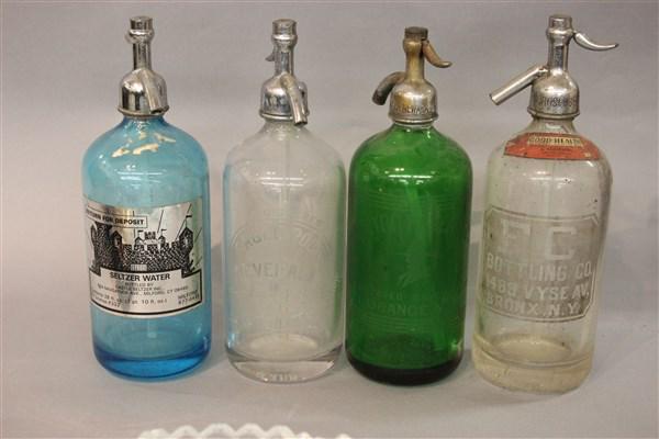 Four Glass Seltzer Bottles: Four vintage glass seltzer bottles. Green glass Puritan Beverages, Orange, New Jersey, FC Bottling Bronx, Milford CT Blue Seltzer and Eagle Rock Mamaroneck, NY.