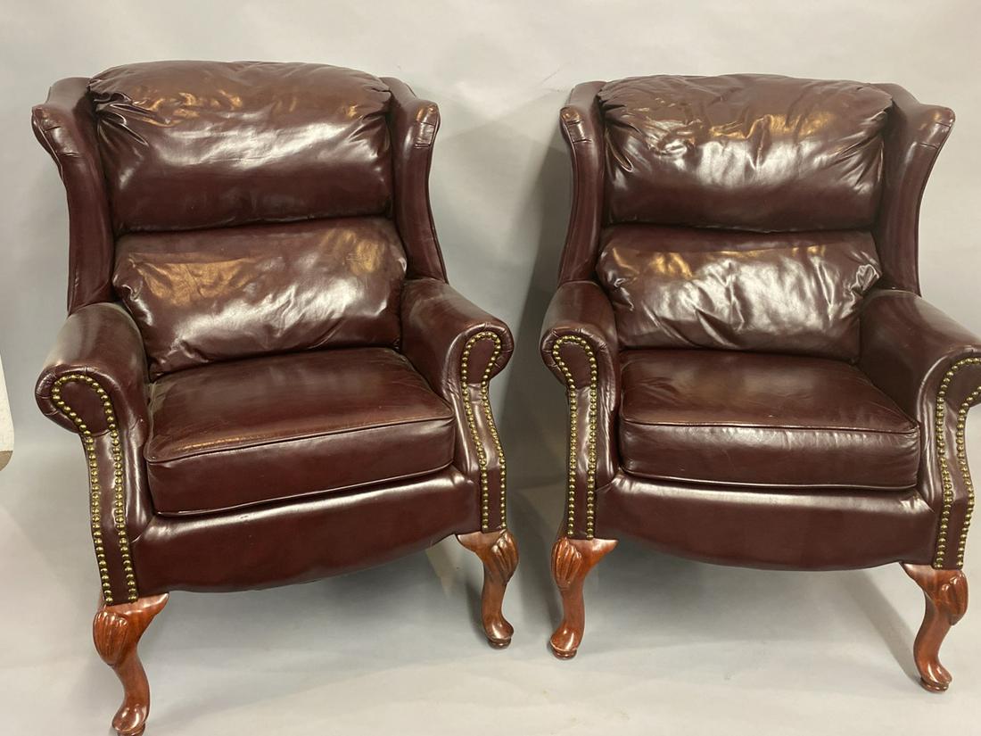 Ox-Blood Red Leather Stuffed Chairs: A pair of Ox-Blood red leather stuffed chairs set on Queen Anne legs. Studded arms.Dimensions: 40"h X 32"w X 31"dCondition Report: Scratch on arm noted. No tears or staining. Clean. Please see photogr
