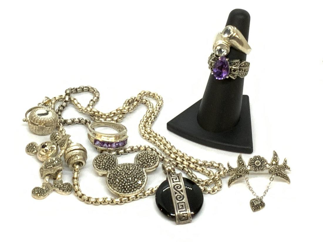 Sterling Silver Jewerly Lot: A compiled grouping of sterling silver jewelry. Disney marcasite Mickey Mouse pins, Nantucket basket pendant, necklaces, amethyst rings etc. Total weight: 3.11 troy ounces