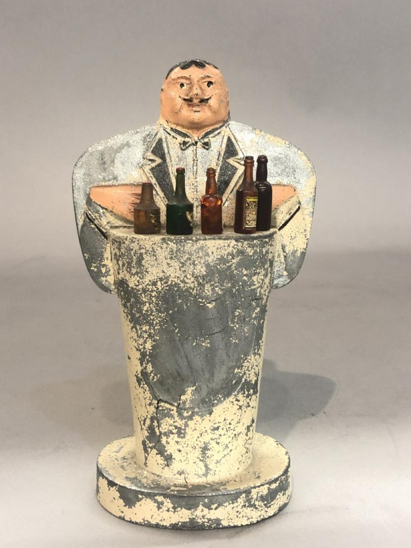 Art Deco Bartender Cocktail Picks: A figural spelter metal bartender cocktail pick holder with liquor bottle top picks. One pick missing. Dimensions: 6 1/2” H x 3 1/2” W