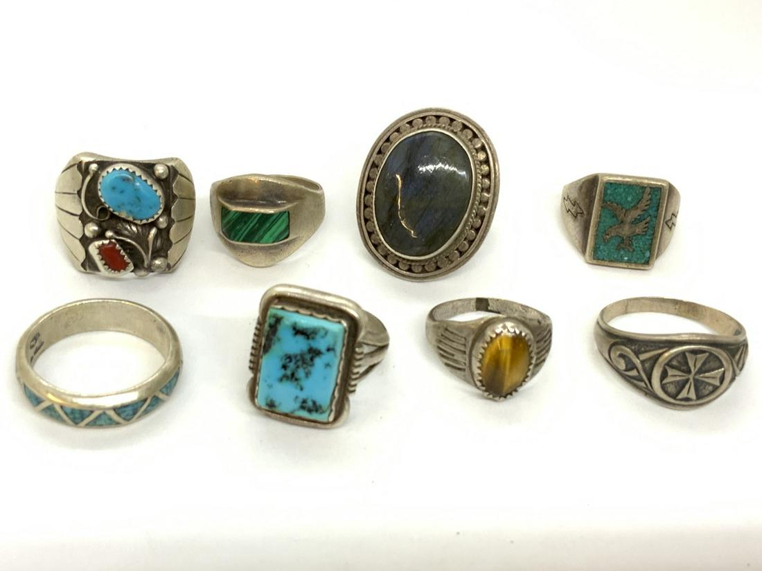 Eight (8) Piece Sterling Silver Ring Lot: Eight (8) piece men's sterling silver ring lot. Cats eye, turqouise, coral and malachite stones. Indian and Mexican. Total weight: 2.93 troy ounces