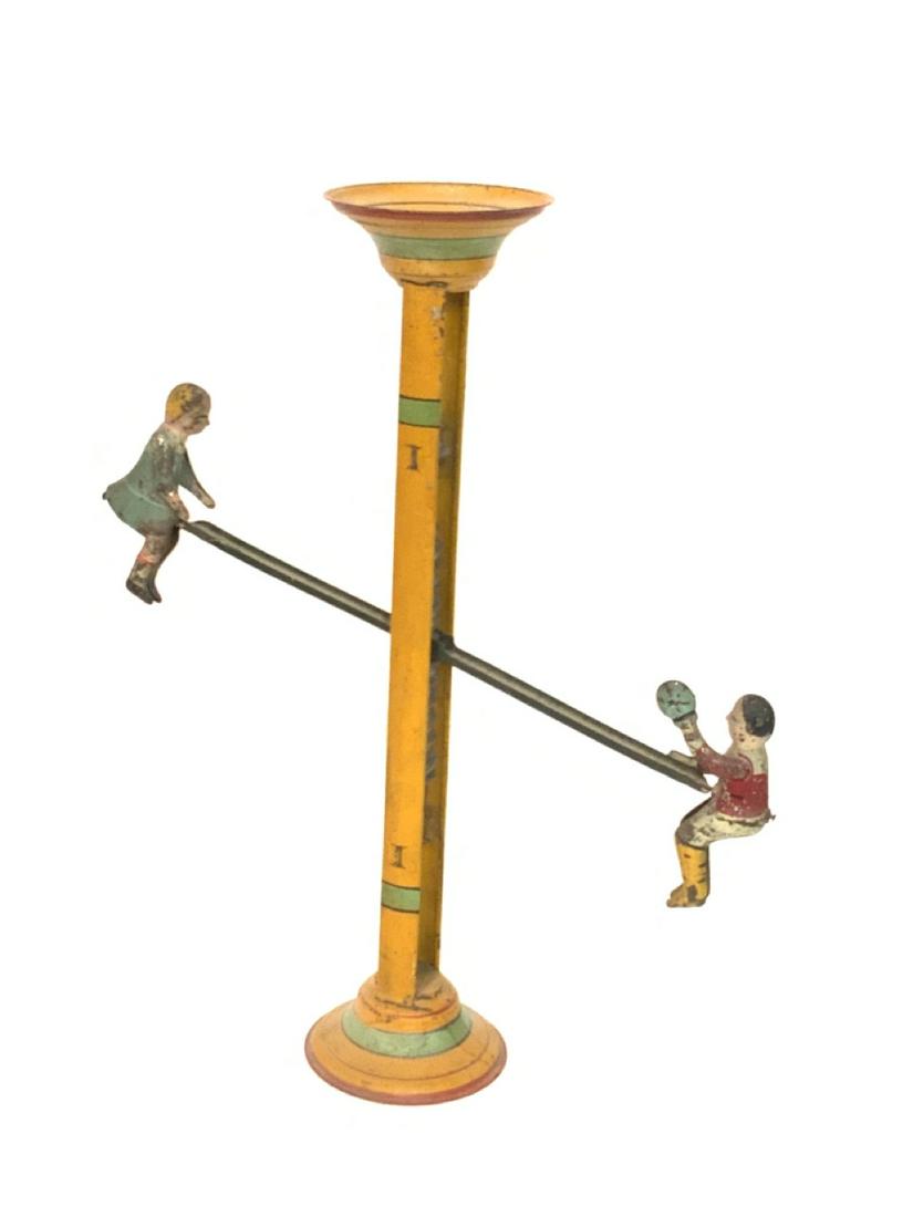 1930's Tin See-Saw Toy: 1930's Tin See-Saw Toy. Dimensions: 15"h X 12"