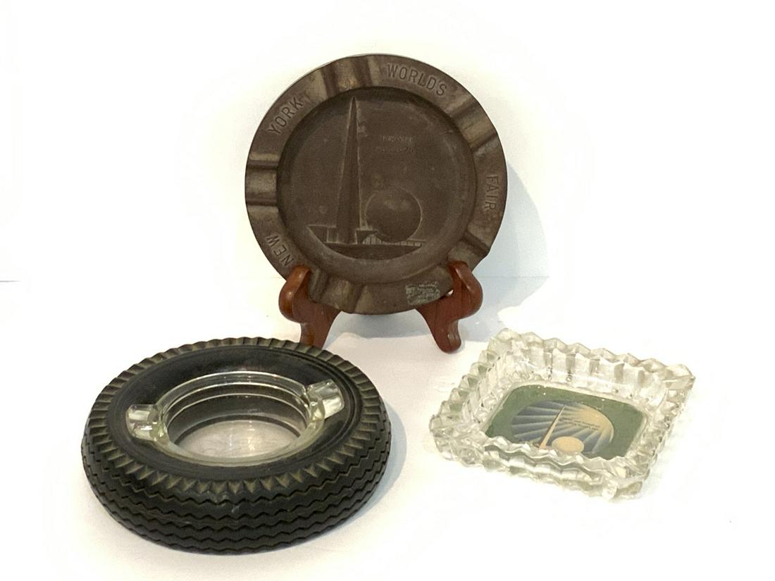 Three (3) 1939 New York World's Fair Ashtrays: Three (3) 1939 New York World's Fair ashtrays. Bakelite, Firestone tires and glass tray with color print of Trylon and Perisphere.