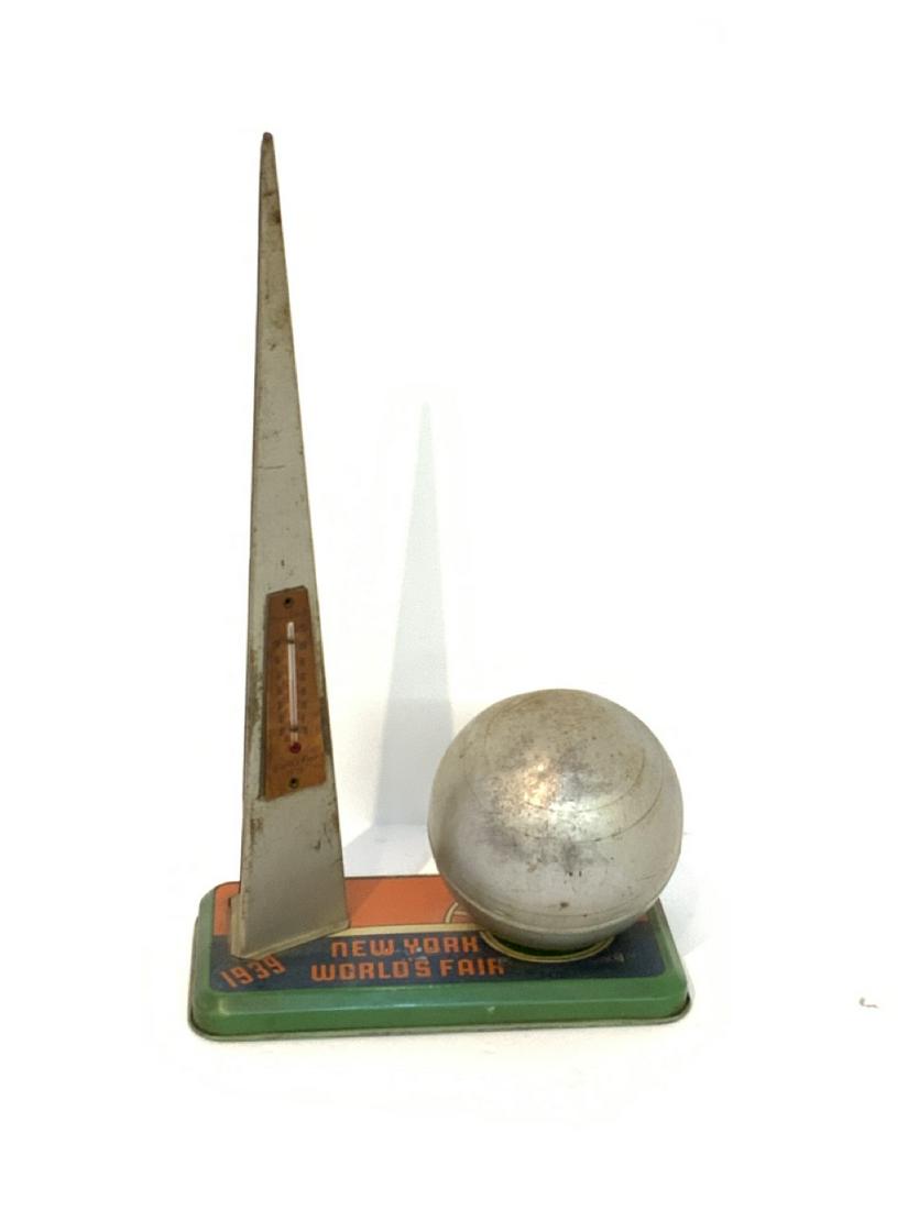 1939 New York World's Fair Trylon And Perisphere Bank: 1939 New York World's Fair trylon and perisphere tin bank and thermometer. Dimensions: 12 1/4" X 7" X 3 1/2"