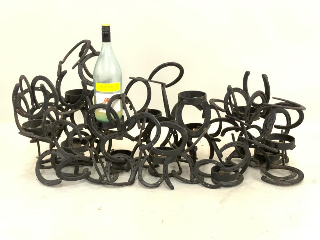 Whimsical Cast Iron Horseshoe Wine Rack: A whimsical cast iron horseshoe wine rack. Artisan piece, 20th century. Dimensions: 19" X 42" X 12"