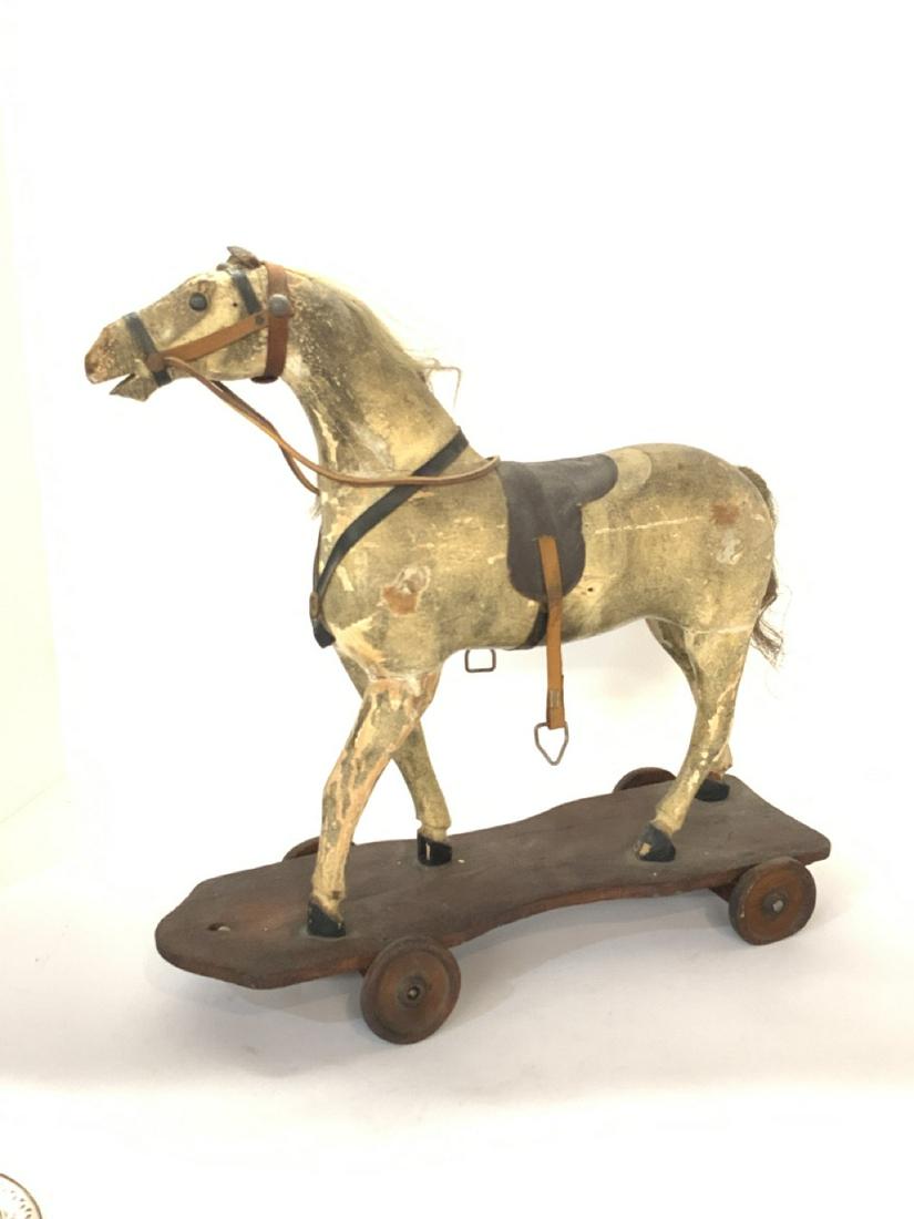 American Folk Art Horse Pull Toy: Antique Folk Art Horse Pull Toy. Painted wood with horse hair mane and tail. Leather reins, metal stirrups with leather straps. Dimensions: 16 1/2"h X 16"w X 6"d