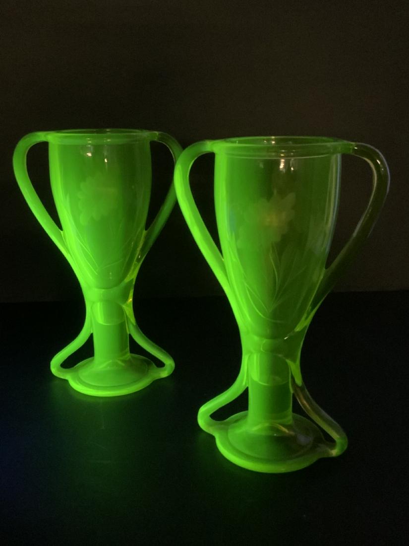 Vaseline Glass Vases: A pair of Vaseline glass double handle trophy style vases. Dimensions: 8 1/2” X 5 1/2”