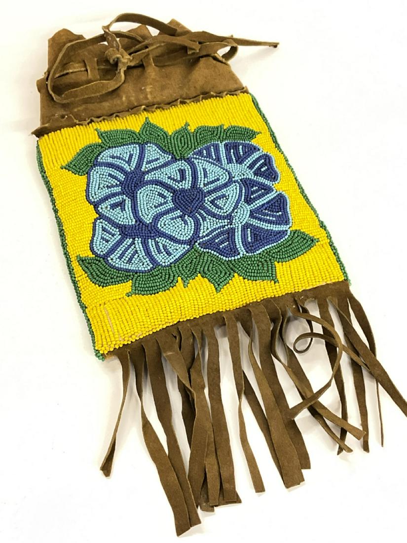 Beaded Indian Hide Bag: Beaded Indian hide pouch with fringe. Handle strap needs replacement. Early 20th century. Dimensions: 14” x 7” with fringe Buyer's Premium