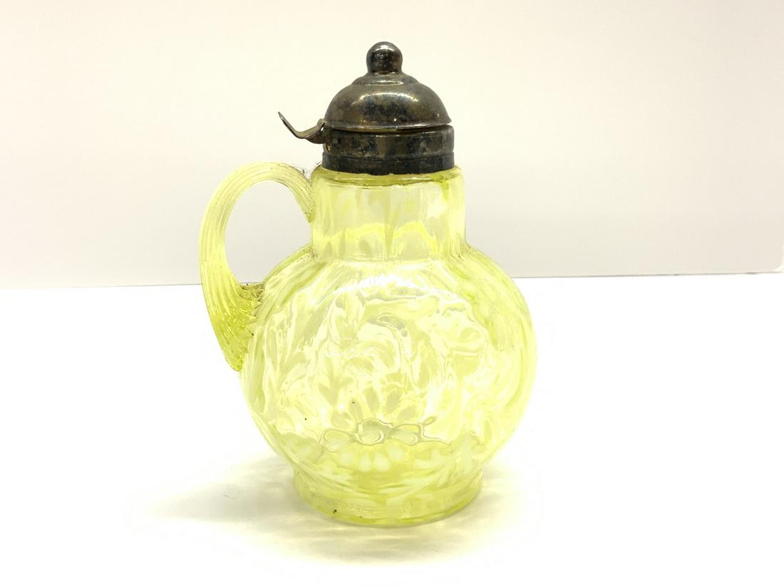 Vaseline Glass Syrup Pitcher: Vaseline glass syrup pitcher. Daisy and fern pattern. Dimensions: 6 1/2" h
