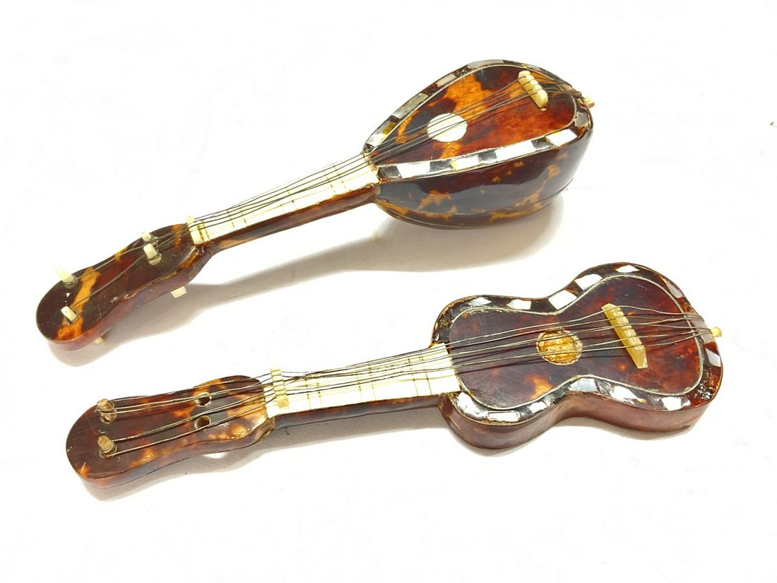 Two Miniature instruments ukulele and a mandolin 5 1/2 inch length by 2 inch: Two (2) Miniature musical instruments. Mandolin and Ukele Dimensions: 5 1/2"L X 2"