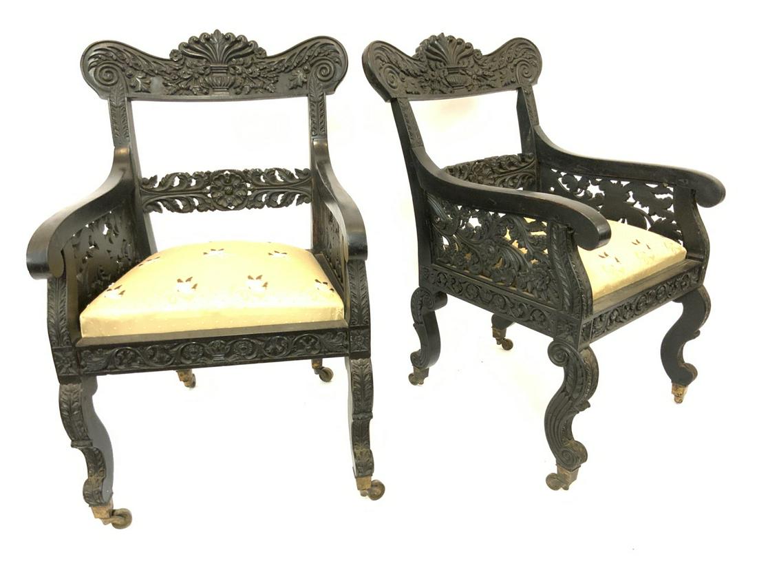 A Pair, 19th c. Anglo Indian Ebonized Carved Wood Arm Chairs: An exceptional pair of 19th century Anglo Indian ebonized carved wood lounge arm chairs. Sri Lanka, 19th century. Dimensions: 24” x 24” x 25 1;2”
