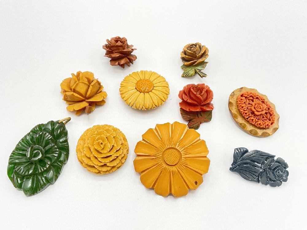 Ten (10) Vintage Carved Bakelite Carved Flower Pins: Ten (10) Vintage carved Bakelite flower pins, pendant and single clip. Dimensions: 1 1/4" X 2 1/4"
