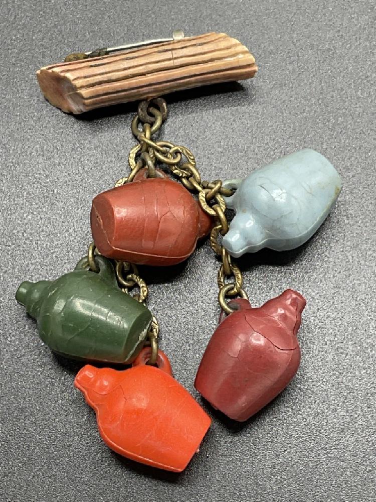 Vintage Bakelite Dangling Jugs Pin: Vintage Bakelite Stoneware Jugs Dangling from wood log pin. Dimensions: 3" X 1"